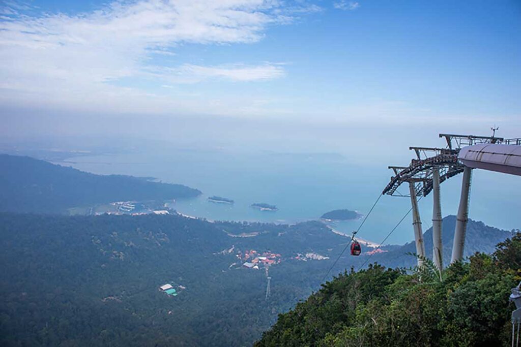 Langkawi SkyCab cable car ascending Gunung Mat Cincang, offering panoramic views of lush green rainforests and the Andaman Sea in Malaysia