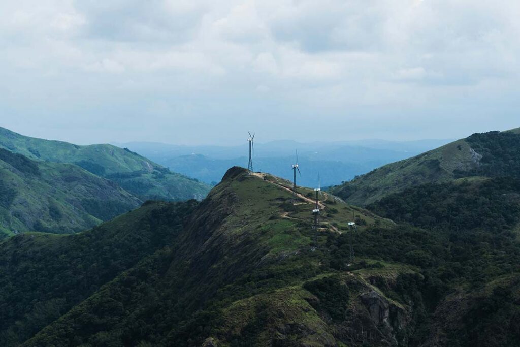 A panoramic view of the majestic Idukki Arch Dam surrounded by lush greenery in Kerala.