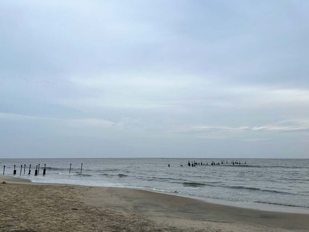 Stunning view of Kozhikode Beach at sunset with golden sands and the iconic pier